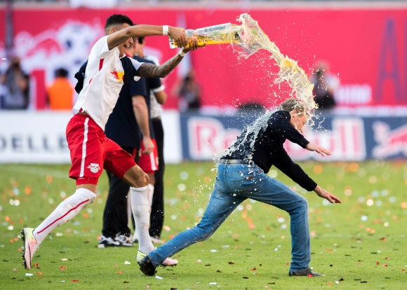 독일 프로축구 분데스리가(1부리그)로 승격하는 RB 라이프치히의 랄프 랑닉(58·독일) 감독이 9일(한국시간) 승격 축하 세리머니 도중 맥주 세례를 피해 도망가다 햄스트링을 다쳐 쓰러지는 황당한 장면이 연출됐다. AFP 연합뉴스