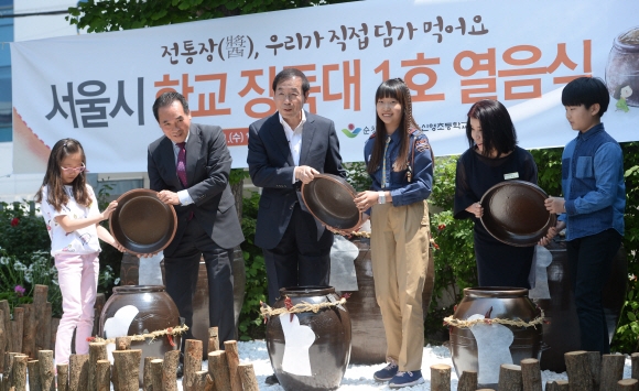 11일 서울 영등포 신영초등학교에서 열린 서울시 학교 장독대 1호 열음식에 참석한 박원순 시장이 장독을 열고 있다.  박지환 기자 popocar@seoul.co.kr