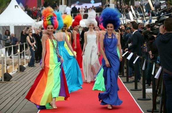 11일(현지시간) 프랑스 칸에서 열린 제69회 칸 영화제 개막식에서 애니메이션 영화 ‘트롤: 노래하는 요정’ 속 주인공과 같은 모습으로 등장한 모델들이 레드 카펫 위를 워킹하고 있다. AP 연합뉴스