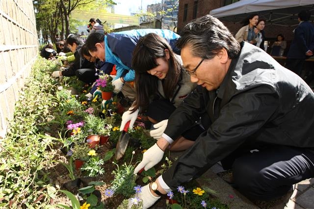 김영종(오른쪽) 종로구청장이 안국동 감고당길 ‘차 없는 거리’ 조성 후 시민들과 꽃을 심고 있다.