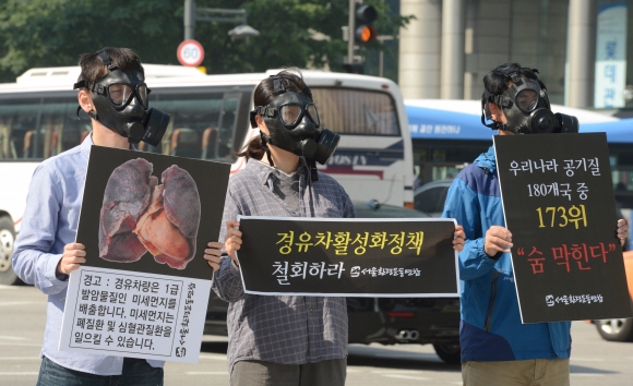 서울환경운동연합 회원들이 17일 서울 종로 광화문 이순신 동상 앞에서 미세먼지를 배출하는 경유차 활성화 정책의 철회를 요구하는 시위를 벌이고 있다. 안주영 기자 jya@seoul.co.kr