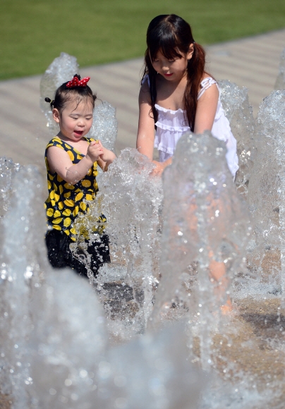 서울 낮 기온이 31도까지 올라가면서 여름날씨를 보인 18일 서울광장 분수대에서 어린이들이 물놀이를 하고 있다.  정연호 기자 tpgod@seoul.co.kr