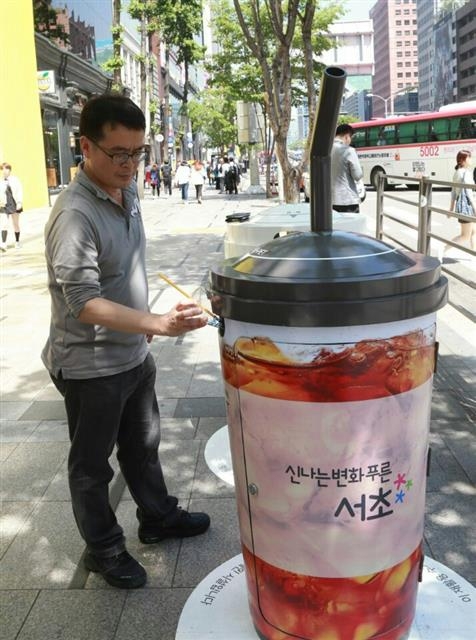 한 시민이 서초구 강남대로에 새로 설치된 커피잔 모양의 재활용 분리 수거함에 다 마신 아이스커피 잔을 넣고 있다. 서초구 제공