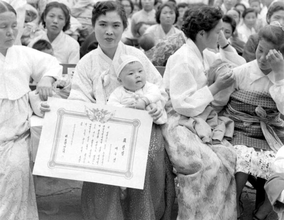 1958년 우량아를 뽑는 대회에서 상장을 받아 든 어머니의 모습.   국가기록원 제공