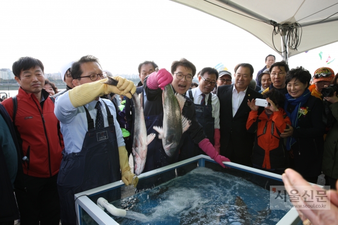 지난해 10월 처음 개장한 서울 성동구 ‘뚝도 활어시장’에서 정원오(가운데) 성동구청장이 활어를 들어보이고 있다.