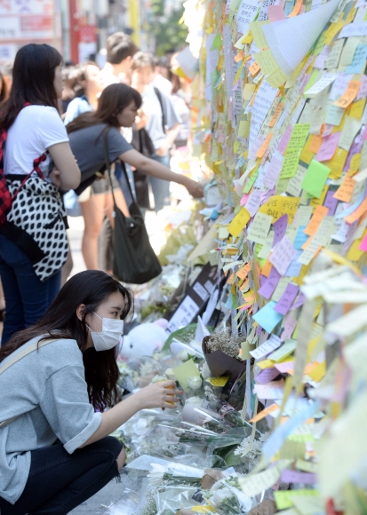 ’강남역 묻지마 살인사건’의 20대 직장인 여성 희생자에 대한 추모 물결이 이어지고 있는 가운데 19일 서울 강남역 10번 출구 앞에 시민들의 추모 메시지를 담은 포스트잇과 국화꽃이 가득 놓여 있다. 박윤슬 기자 seul@seoul.co.kr