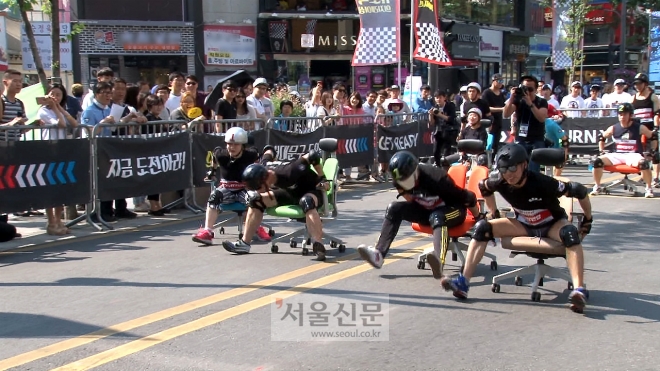 22일 서울 서대문구 연세로 차 없는 거리에서 진행된 ‘2016 듀오백&서대문구 의자 레이싱’ 행사에서 참가자들이 의자를 이용해 힘껏 달리고 있다.