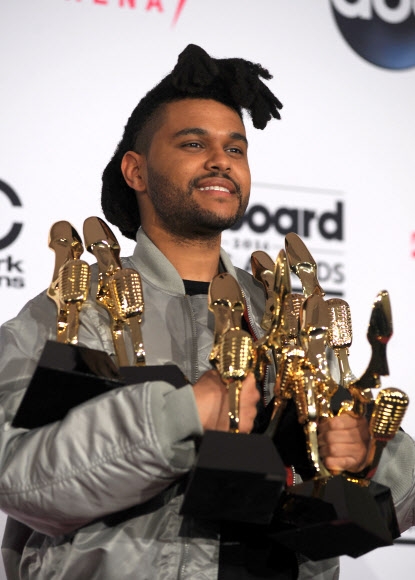 22일(현지시간) 미국 네바다주 라스베이거스 티 모바일 아레나에서 열린 2016 빌보드 뮤직 어워드에서 6관왕을 차지한 위켄드가 양손 가득 트로피를 들고 미소를 짓고 있다. 위켄드는 이날 ‘톱 핫 100 아티스트’, ‘톱 송 세일즈 아티스트’, ‘톱 라디오송 아티스트’, ‘톱 스트리밍송 아티스트’, ‘톱 알앤비 앨범’, ‘톱 스트리밍송(오디오)’을 차지했다.  AFP 연합뉴스