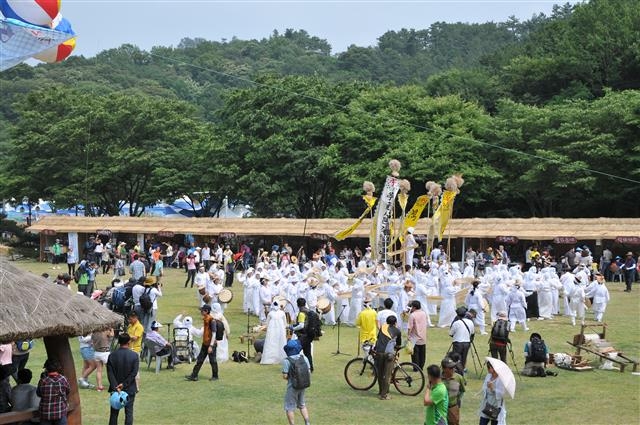 무더위를 날리는 천연의 섬유 모시 가운데 가장 유명한 한산모시를 주제로 한산모시문화제가 다음달 3일부터 6일까지 충남 서천군 한산모시관 일대에서 열린다. 사진은 모시산업의 전통을 알리는 저산팔읍 길쌈놀이.  서천군 제공