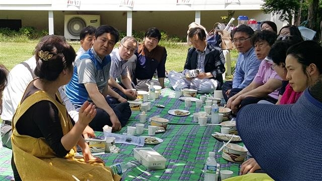 김영배(왼쪽 세 번째) 성북구청장이 정원축제가 열린 정릉 교수단지의 한 단독주택 잔디밭에서 마을만들기 사업을 하는 주민의 이야기를 듣고 있다. 성북구 제공
