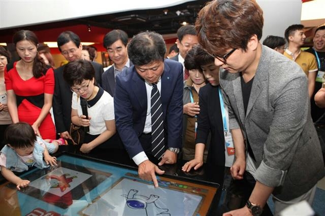 김만수(가운데) 경기 부천시장이 25일 중국 산둥성 옌타이시에서 문을 연 한·중 만화영상체험관에서 관람객에게 우리나라 만화 콘텐츠에 대해 설명하고 있다. 부천시 제공