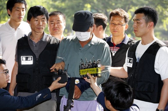 수락산 등산객 살인사건 용의자 김모 씨(61)가 조사를 받기 위해 30일 오전 서울 노원경찰서로 이송되고 있다.  연합뉴스