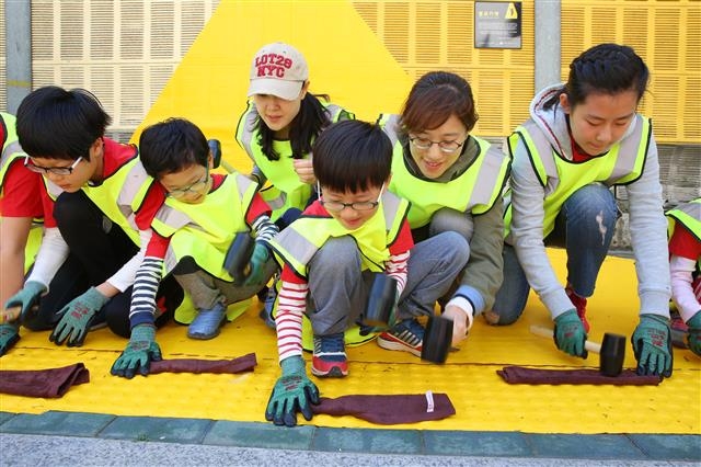 서울 서초구 양재동 양재초등학교 인근에서 주민과 학생들이 어린이 보행 안전을 위한 옐로카펫을 설치하고 있다. 서초구 제공
