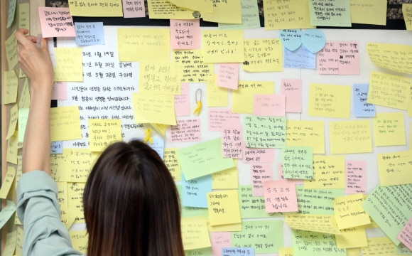 31일 서울 광진구 2호선 구의역 역무실 옆에 마련된 스크린도어 수리공 사망 사고 추모공간에 한 시민이 희생자를 추모하는 포스트잇을 붙이고 있다.  박윤슬 기자 seul@seoul.co.kr