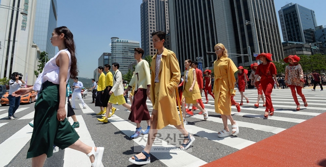 2일 서울 중구 세종대로 서울시청 신청사와 시의회 건물 사이에 신설된 횡단보도에서 열린 횡단보도 패션쇼에 참가한 모델들이 3색 신호등을 모티브로 제작된 의상을 입고 횡단보도를 건너고 있다. 손형준 기자 boltagoo@seoul.co.kr