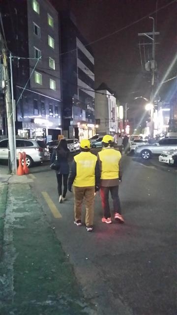 서울 동작구의 한 주민이 안심귀가 스카우트의 도움을 받아 귀가하고 있다. 동작구 제공