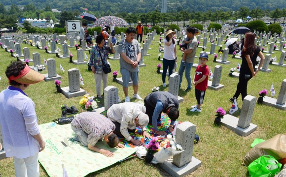 현충일을 하루 앞 둔 5일 서울 동작구 현충원을 찾은 참배객들이 절을 하고 있다.    정연호 기자 tpgod@seoul.co.kr