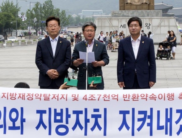 채인석(가운데) 경기 화성시장과 이재명(왼쪽) 성남시장, 염태영 수원시장이 7일 서울 광화문광장에서 열린 ‘지방재정 개편 반대 기자회견’에서 중앙정부에 지방재정 반환 약속을 지키라고 촉구하고 있다. 이들은 기자회견 뒤 단식 농성에 들어갔다.연합뉴스