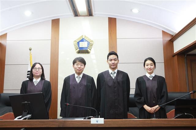 하루 명예법관에 선정된 배우 박진희(오른쪽)씨가 9일 서울 서초구 법원종합청사에서 판사들과 기념촬영을 하고 있다. 서울중앙지법 제공