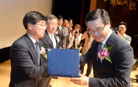 성장현(오른쪽) 서울 용산구청장이 9일 이태원동 용산구청 내 용산아트홀 대극장에서 열린 용산복지재단 출범식에서 공로자들에게 시상을 하며 활짝 웃고 있다.이언탁 기자 utl@seoul.co.kr