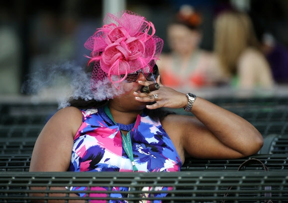 11일(현지시간) 미국 뉴욕주 엘몬트에서 열린 ‘제148회 벨몬트 스테이크스 경주대회(Belmont Stakes)’ 에 특이한 모자를 쓴 관람객이 담배를 피며 경기를 지켜보고 있다 AP 연합뉴스