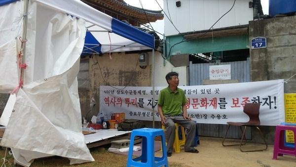 소반장 추용호 장인이 소방도로 개설을 위해 강제 철거 예정지로 지정된 경남 통영시 도천동 공방 앞에서 보존을 주장하며 시위하고 있다. 부산일보 제공
