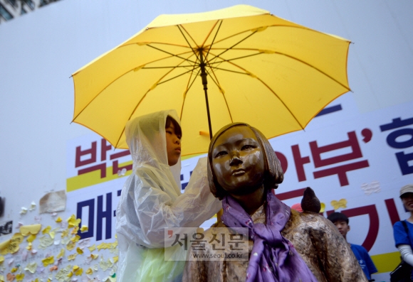 ‘비오는 날의 수요집회’... 소녀상에 우산 씌워주는 학생