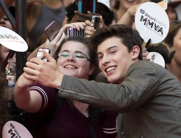 캐나다 출신 싱어송라이터 션 메데스가 19일(현지시간) 캐나다 토론토에서 열린 ‘머치뮤직 비디오 어워즈(Much Music Video Awards)’에 참석해 레드 카펫에서 팬들과 사진을 찍고 있다. AP 연합뉴스