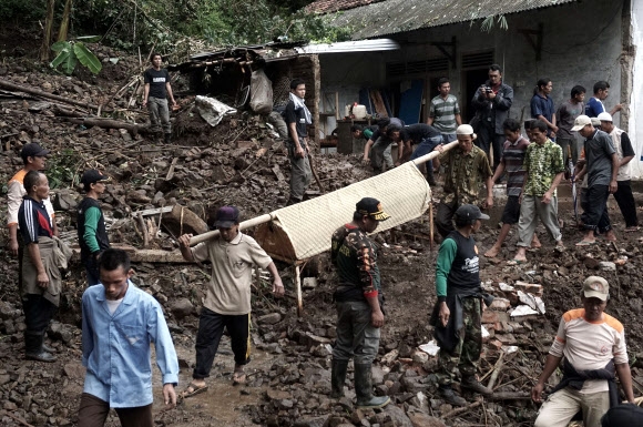 인도네시아서 홍수·산사태 발생... 시신 옮기는 사람들
