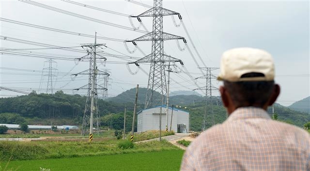 충남 청양군 청양읍 청수리의 한 주민이 송전탑과 송전선이 빼곡한 마을과 들판을 쳐다보고 있다. 주민들은 송전선에서 발생하는 소음 공해 때문에 스트레스가 심하고 암 등 중병에 걸리지 않을까 내내 마음이 놓이지 않는다고 걱정했다.