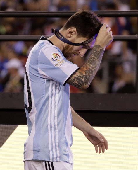 아르헨티나 대표팀의 리오넬 메시가 27일 칠레와의 코파 아메리카 센테나리오 결승에서 승부차기 끝에 우승을 내준 뒤 시상식에서 은메달을 수여받은 뒤 화가 난 듯 곧바로 벗어버리고 있다. 이스트 러더포드 AP 연합뉴스