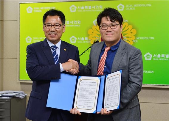 서울시의회 강감창 새누리 원내대표(왼쪽)와 김종욱 더불어민주 원내대표(오른쪽)가 원구성에 관한 합의문을 교환하고 악수하고 있다.