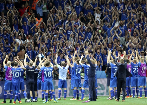 아이슬란드의 선수들이 27일(현지시간) 프랑스 니스 알리안츠 리비에라에서 열린 잉글랜드와의 유로 2016 16강전 경기에서 2-1로 승리하며 8강 진출을 확정 지은 뒤 팬들과 함께 축하 세리머니를 하고 있다. AP 연합뉴스