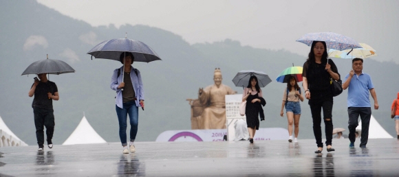 전국이 북상하는 장마전선의 영향을 받는 1일 서울 광화문 광장을 지나는 시민들이 내리는 비에 발걸음을 재촉하고 있다. 기상청은 이날 전국이 대체로 흐리고 낮에 서쪽 지방에서 비(강수확률 60~90%)가 시작되어 오후에는 전국으로 확대되겠다고 밝혔다. 예상 강수량은 강원 동해안을 포함한 전국 내륙이 5~30mm다. 지역별로 중부지방은 50~100mm, 많은 곳은 150mm 이상이고, 남부지방과 서해5도는 20~60mm, 제주도는 10~40mm다.  이언탁 기자 utl@seoul.co.kr