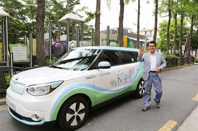 서울의 환경문제 해결을 위해 관용차를 전기차로 바꾼 유종필 관악구청장이 ‘맑은 공기 관악’이란 스티커가 붙어 있는 관용 전기차 앞에서 기념사진을 찍고 있다. 관악구 제공
