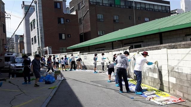 자원봉사자들이 범죄 예방을 목적으로 서울 노원구 상계1동의 학교 담장을 도색하고 있다. 노원구 제공