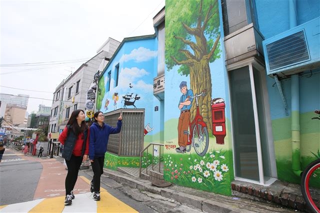 각종 만화 캐릭터와 벽화 그림이 가득한 명동 재미로 거리를 관람객들이 지나고 있다. 중구 제공