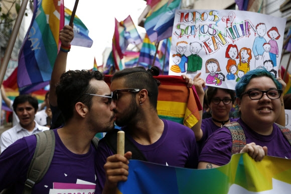 9일(현지시간) 파라과이 아순시온에서 열린 게이 프라이드 퍼레이드(gay pride parade)에서 참가자들이 거리행진을 하며 키스를 나누고 있다. AP 연합뉴스