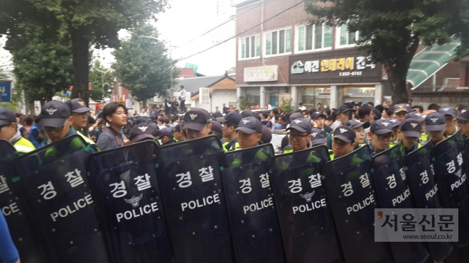 경찰들이 방패를 들고 황교안 국무총리가 탄 차를 보호하고 있다.