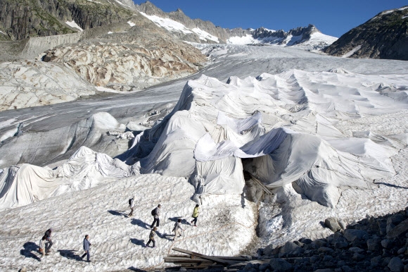 19일 스위스 알프스 산맥 해발 2429m 지점의 푸르카패스 인근에 위치한 론 빙하가 녹는 것을 막기 위해 특수 제작된 하얀 천이 덮여 있다.  EPA 연합뉴스