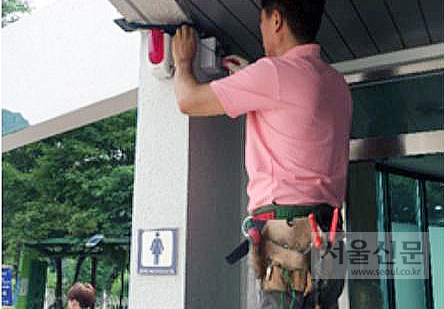 군포시 관계자가 공중화장실에 비상벨을 설치하고 있다. 군포시 제공 