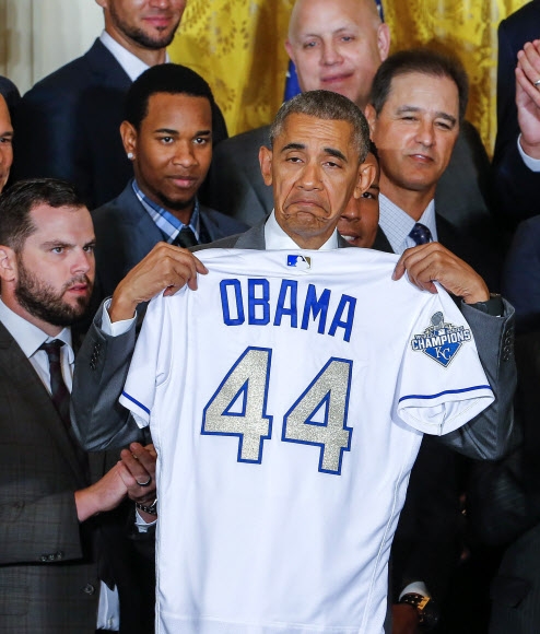 버락 오바마 미국 대통령이 21일(현지시간) 미국 워싱턴 D.C 백악관에서 미국 프로야구 2015년 월드 시리즈 우승 팀인 캔자스시티 로열스의 명예 멤버로 임명돼 자신의 이름이 새겨진 유니폼을 들어 보이고 있다.  EPA 연합뉴스