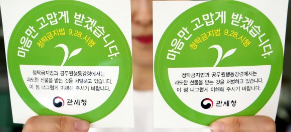 관세청이 ‘부정청탁 및 금품 등 수수의 금지에 관한 법률’(김영란법) 시행에 대비해 공무원들에게 명절이나 휴가철 등에 배달된 선물을 돌려줄 때 상자에 부착하는 ‘청렴스티커’를 5000장 제작해 본청과 전국 세관에 배포했다. 26일 관세청 한 직원이 청렴스티커를 들어 보이고 있다. 대전 연합뉴스