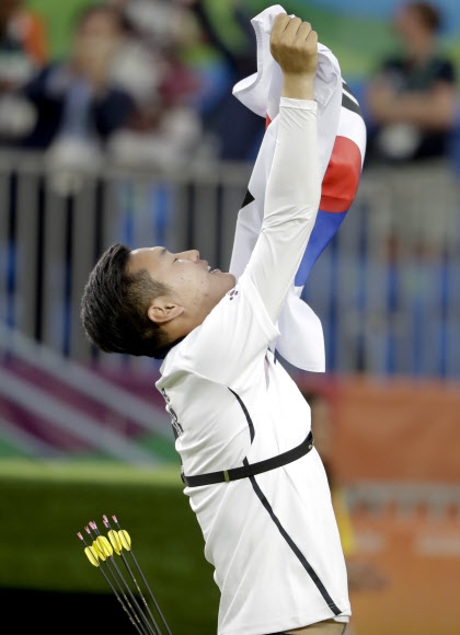 구본찬이 7일 리우 올림픽 양궁 남자 단체전 결승에서 미국을 6-0으로 제압한 뒤 태극기를 치켜들고 환호하고 있다. 브라질 리우데자네이루 AP 연합뉴스