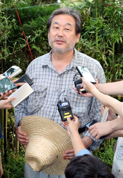 배낭여행을 마치고 8일 서울로 돌아온 새누리당 김무성 전 대표가 여의도 자택 앞에서 기자들과 만나 질문에 답하고 있다.  연합뉴스 