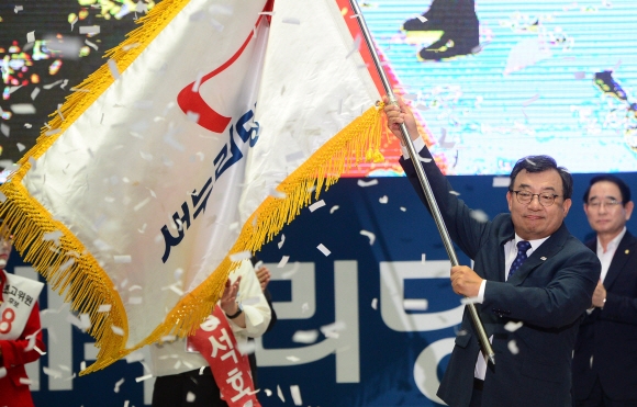 이정현 새누리당 신임 당 대표가 9일 서울 잠실실내체육관에서 열린 전당대회에서 당기를 흔들며 당선 축하를 받고 있다. 정연호 기자 tpgod@seoul.co.kr