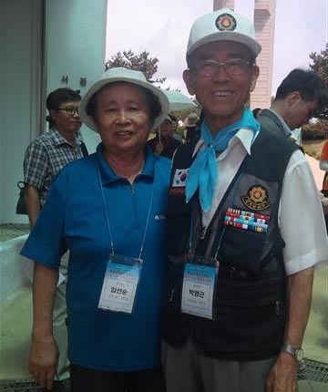 6·25전쟁 때 중부전선 작전에 투입돼 왼쪽 팔다리에 부상을 당한 박영근(오른쪽)씨가 10일 ‘DMZ 통일열차 여행’ 참가 중 백마고지 전적비 앞에서 부인과 기념촬영을 하고 있다. 1952년 10월 중공군 2개 사단과 벌인 전투로 열흘 사이에 24차례나 주인이 바뀌었던 현장이다. 행정자치부 제공