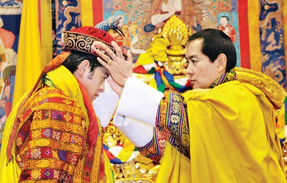 2006년 12월 퇴위한 부탄의 지그메 싱기에 왕추크(오른쪽)전 국왕이 2008년 11월 수도 팀푸의 왕궁에서 열린 대관식에서 후계자인 지그메 케사르 남기엘 왕추크에게 왕관을 씌워 주고 있다. 서울신문 DB