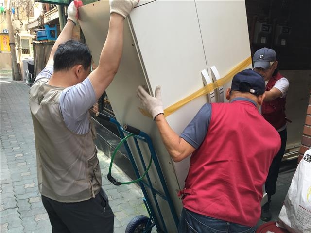 ‘마을집사 프로젝트 돈의동 홍반장’ 사업에 참여한 쪽방촌 주민들이 이웃의 이사를 돕고 있다.