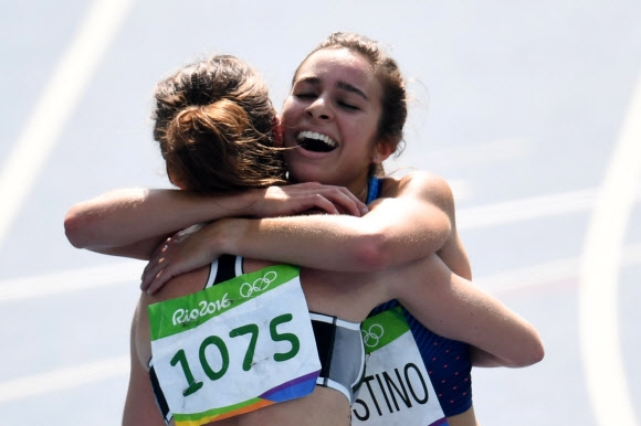 니키 햄블린(왼쪽 뉴질랜드)가 16일(현지시간) 리우올림픽 육상 여자 5000m 예선 결승선을 들어온 뒤 서로 일으켜 세워주고 부축하며 레이스를 완주한 애비 다고스티노(미국)와 감격의 포옹을 나누고 있다. 리우데자네이루 AFP 연합뉴스